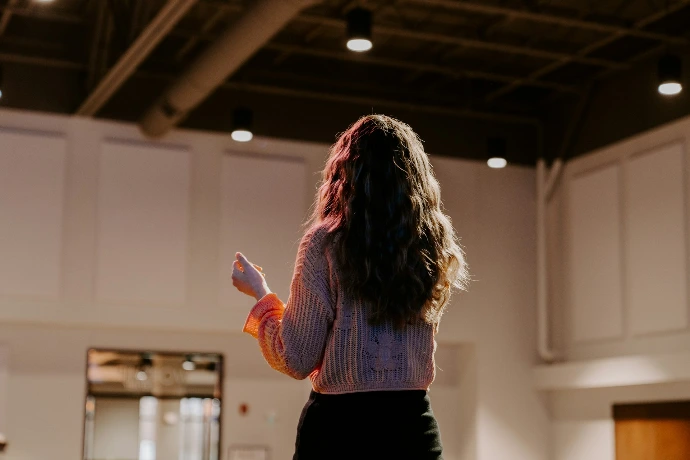 a woman standing in a room holding a remote
